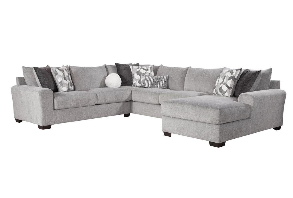 Light grey U-shaped sectional sofa by Behold with plush cushions and modern design, shown in a stylish living room setting.