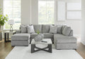 Grey plush U-shaped sectional sofa with chaise, Ashley Casselbury 2-piece design in cement fabric, shown in a living room setting.