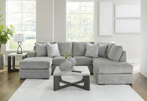 Grey plush U-shaped sectional sofa with chaise, Ashley Casselbury 2-piece design in cement fabric, shown in a living room setting.