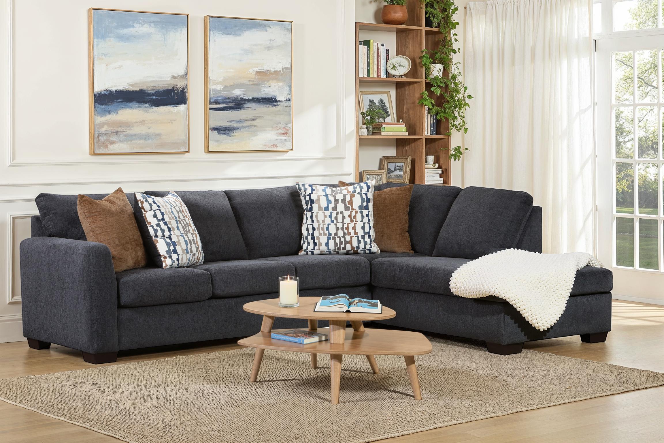 Dark blue Behold L-shaped sectional sofa with plush cushions and modern design, shown from a side angle in a living room setting.