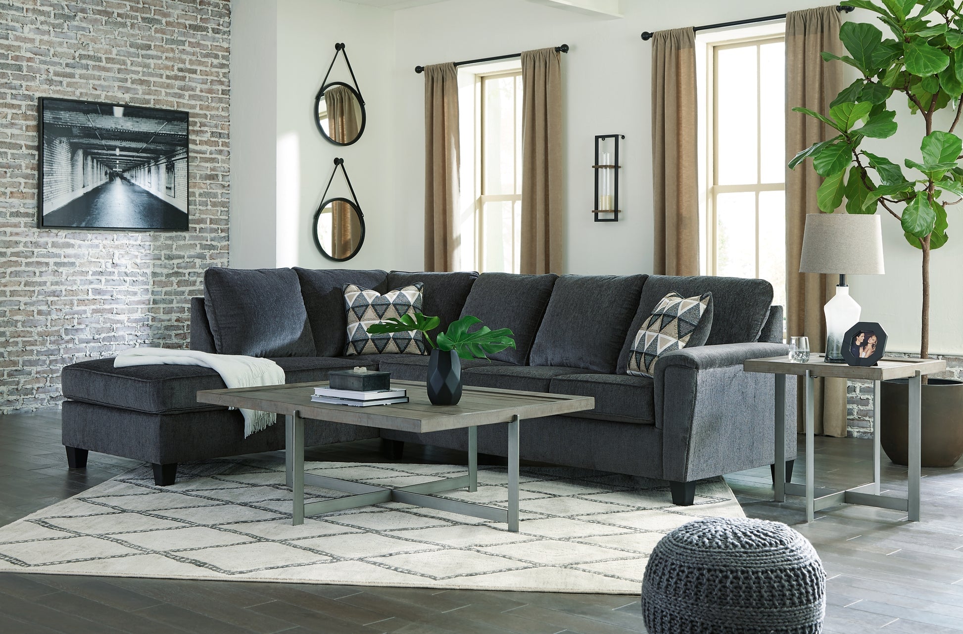 Slate grey Ashley L-shaped sectional sofa in a modern studio, showcasing plush cushions and sleek design.