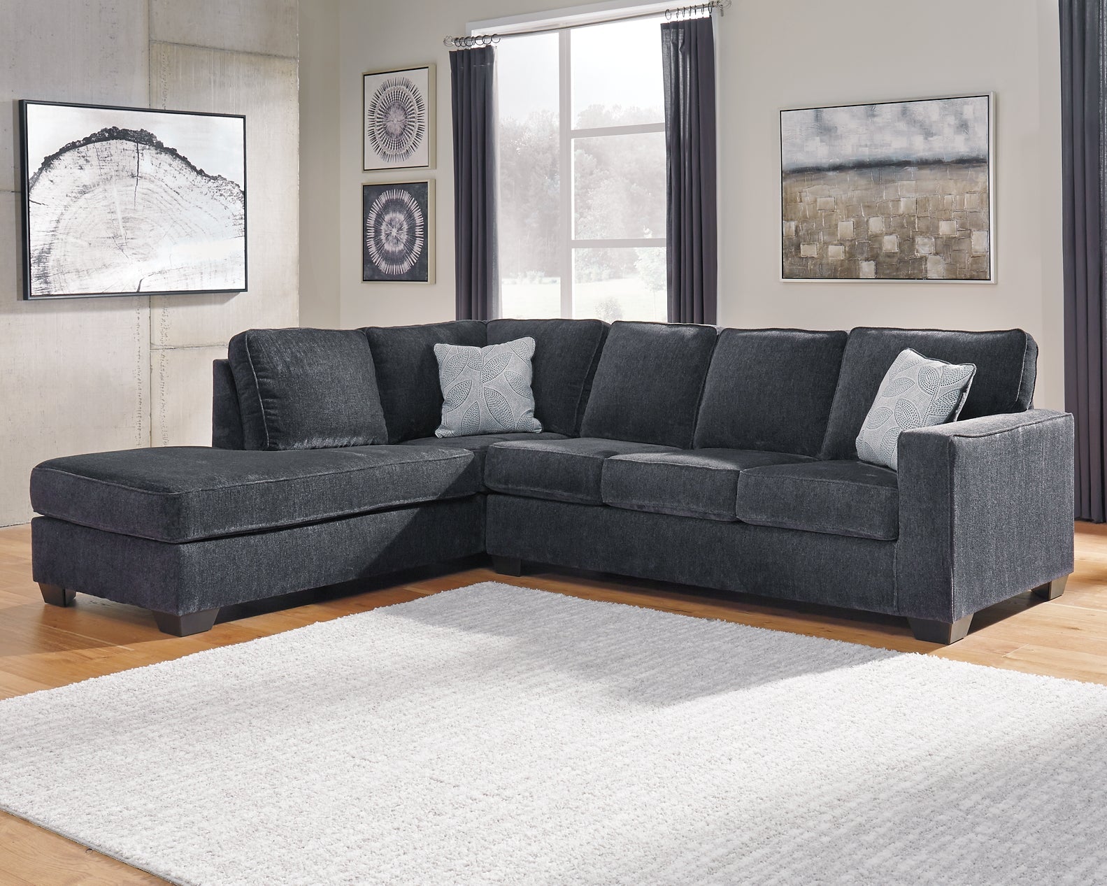 Slate grey Ashley L-shaped sectional sofa in a modern studio setting, showing plush cushions and sleek upholstery.