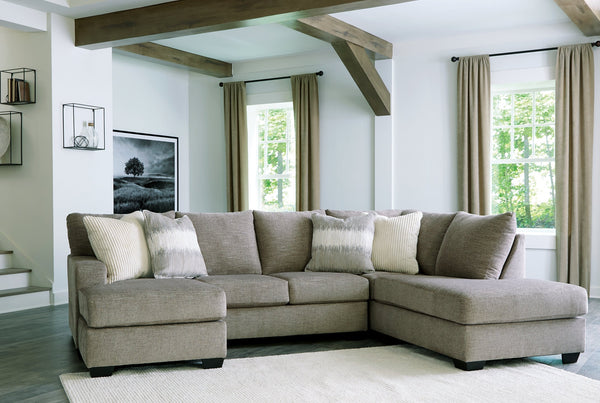 Beige U-shaped sectional sofa by Ashley, shown in a modern living room setting with plush cushions and clean lines.