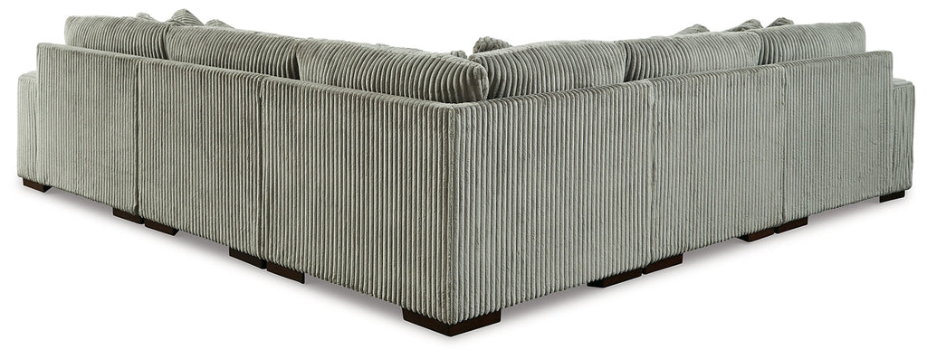 Green corduroy L-shaped sectional sofa by Ashley in a modern studio setting, showcasing plush cushions and stylish design.