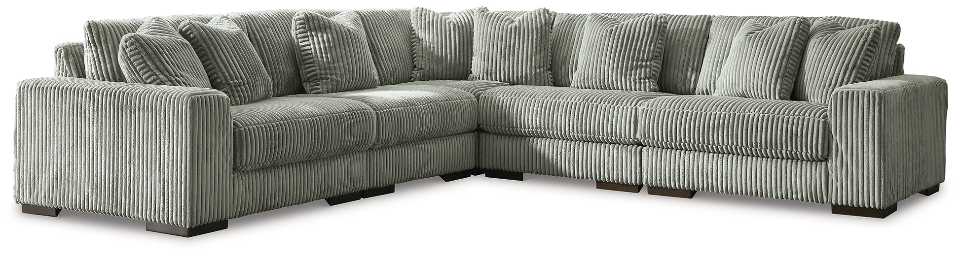 Green corduroy L-shaped sectional sofa by Ashley, shown in a modern studio setting with plush cushions and sleek design.