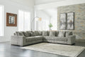 Green corduroy L-shaped sectional sofa by Ashley, shown in a modern studio setting with plush cushions and a spacious design.