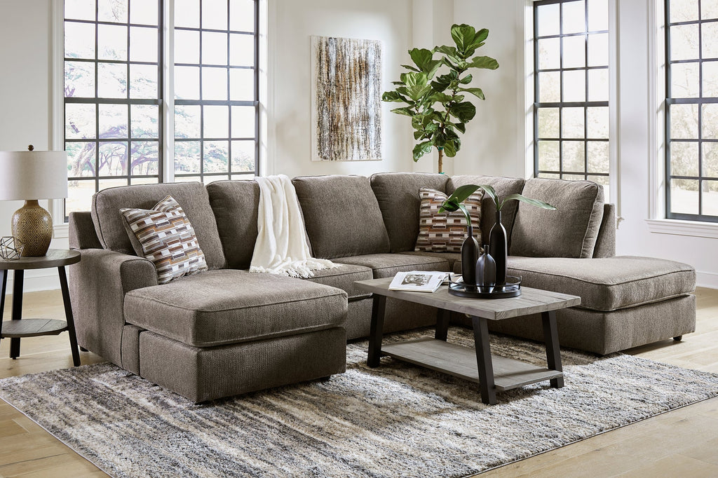 Brown U-shaped sectional sofa by Ashley with plush cushions and modern design, shown in a stylish living room setting.