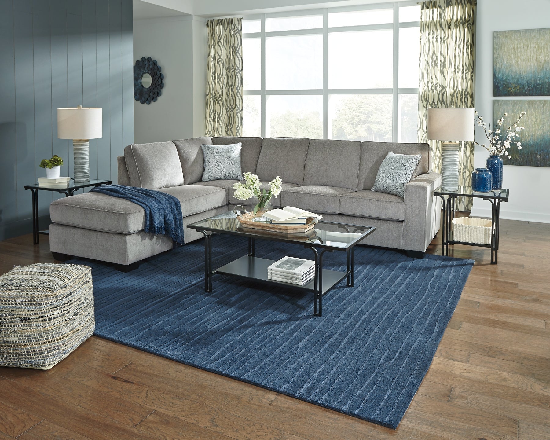 Grey Ashley L-shaped sleeper sectional sofa with plush cushions and modern design, shown in a stylish studio setting.