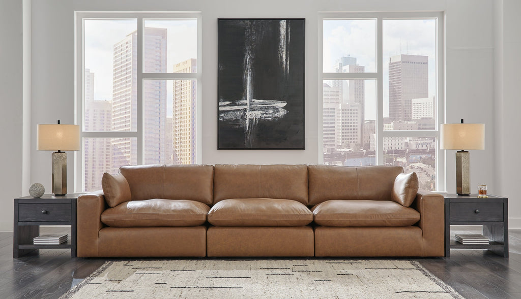 Genuine leather 3-piece sectional sofa by Ashley in a modern studio setting, featuring plush cushions and sleek design.