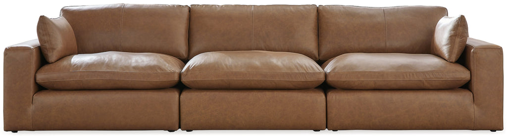 Genuine leather sectional sofa from Ashley with three pieces, featuring plush cushions and a modern design in a studio setting.