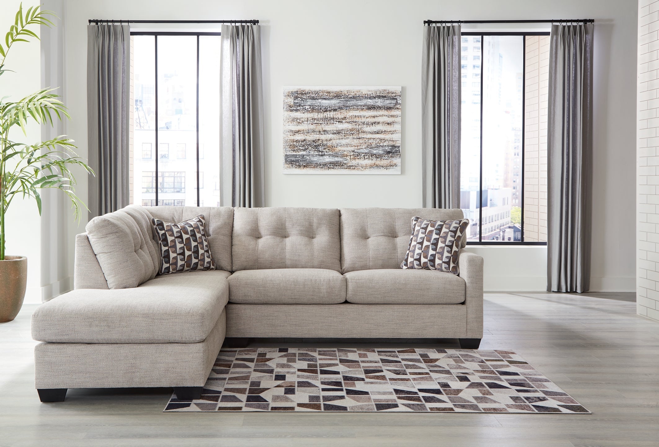 Beige Ashley L-shaped sectional sofa in a modern studio setting, featuring plush cushions and sleek fabric upholstery.
