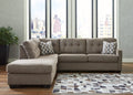 Brown Ashley L-shaped sectional sofa in a modern studio setting, showcasing plush cushions and spacious seating arrangement.