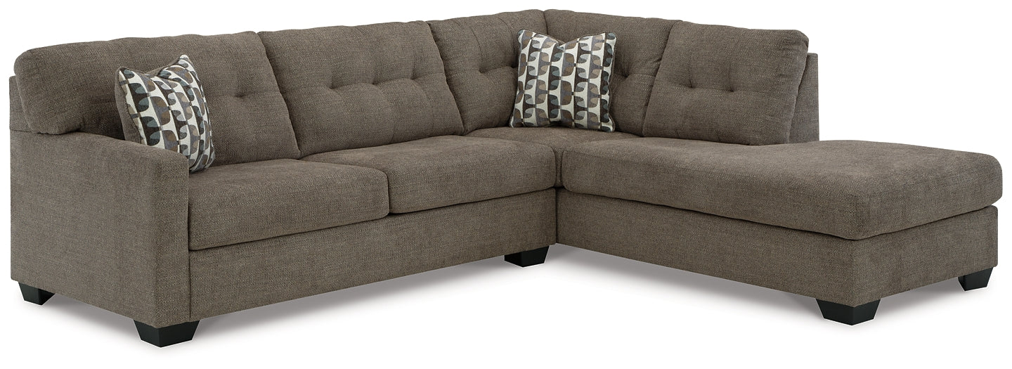 Brown Ashley L-shaped sectional sofa in a modern studio setting with plush cushions and spacious seating.