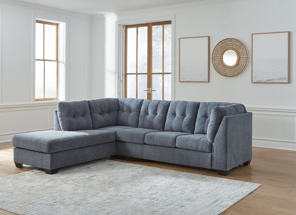 Blue Ashley L-shaped sectional sofa in a modern studio setting with plush cushions and sleek design.