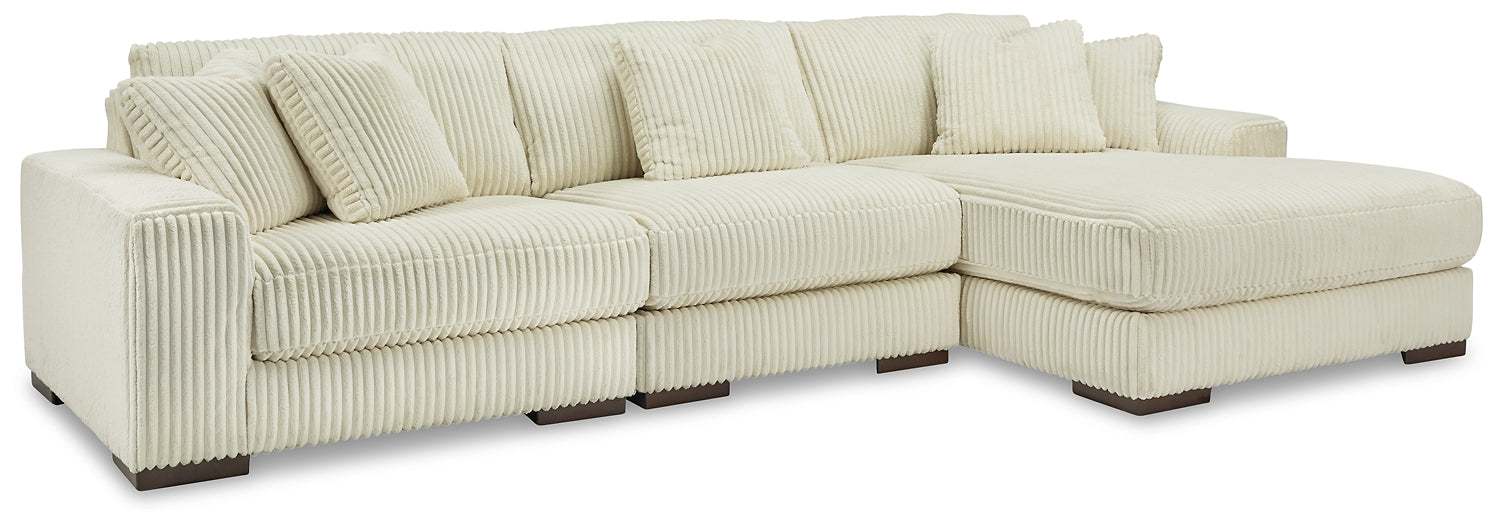 Ivory corduroy sofa chaise by Ashley, showing plush fabric and sleek design in a modern living room setting.