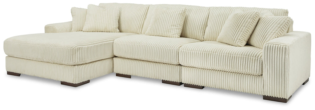Ivory corduroy sofa chaise by Ashley showing plush fabric and sleek design in a modern studio setting