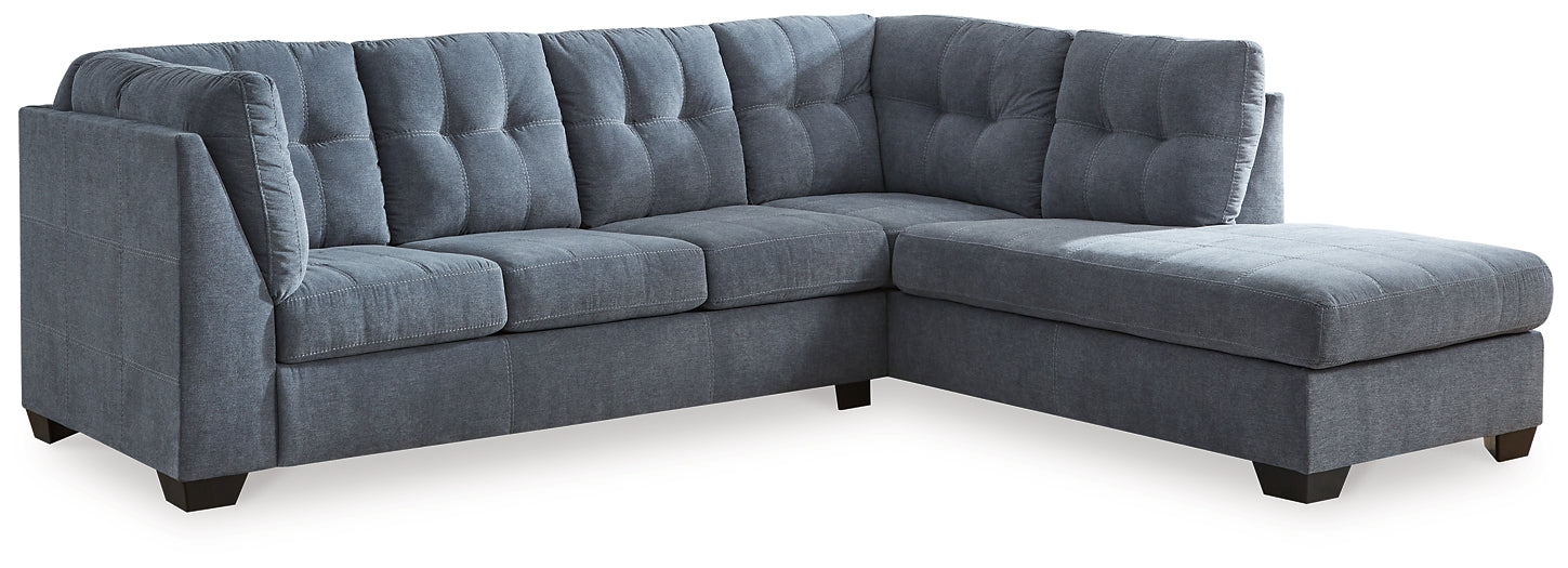 Blue Ashley L-shaped sectional sofa in a modern studio setting, showcasing plush cushions and sleek design.