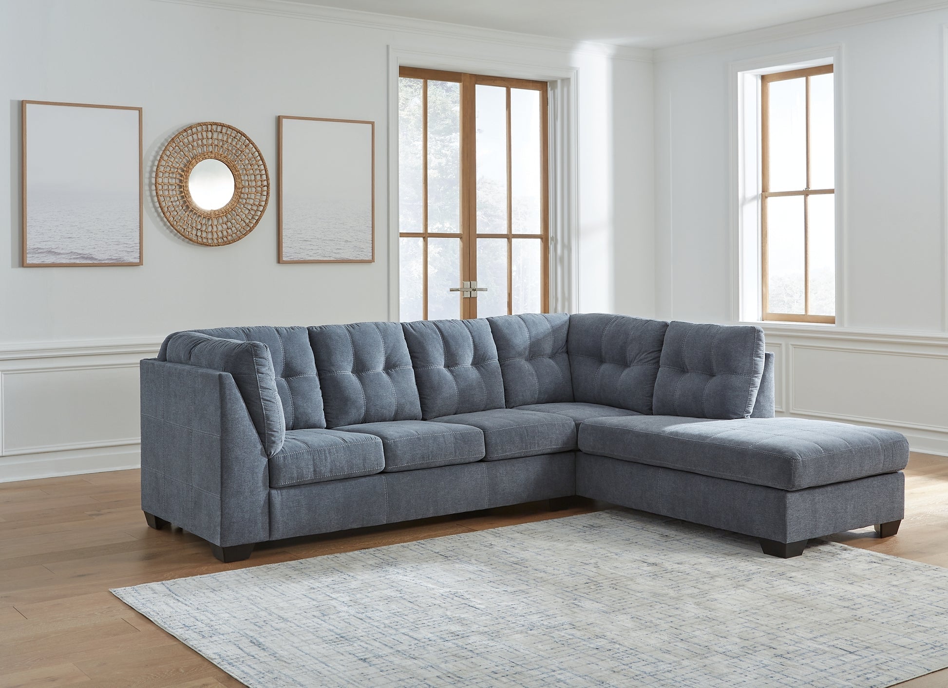 Blue Ashley L-shaped sectional sofa in a modern studio setting, showcasing comfortable seating and stylish design.