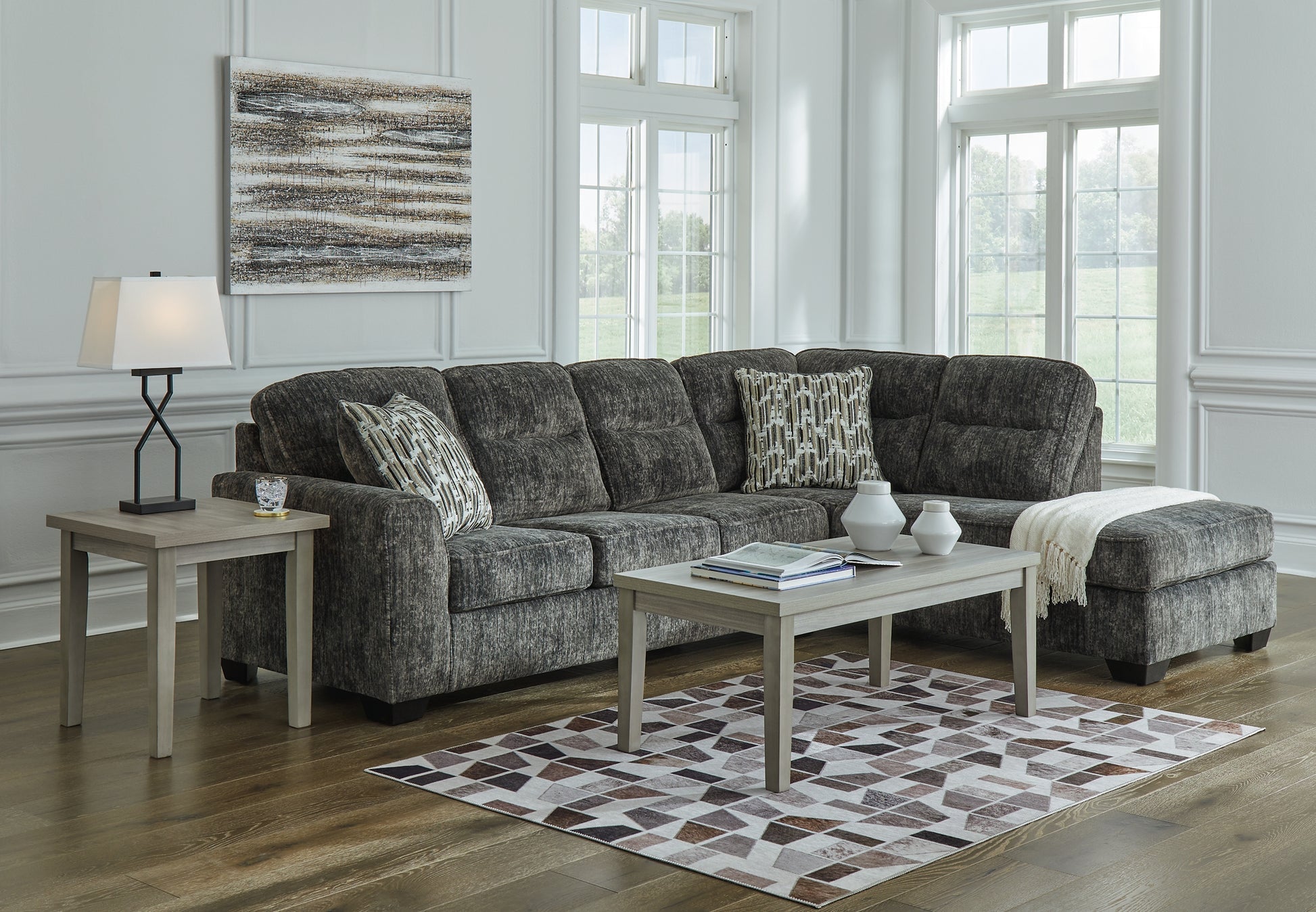 Grey Ashley L-shaped sectional sofa with plush cushions and modern design, shown in a stylish studio setting.