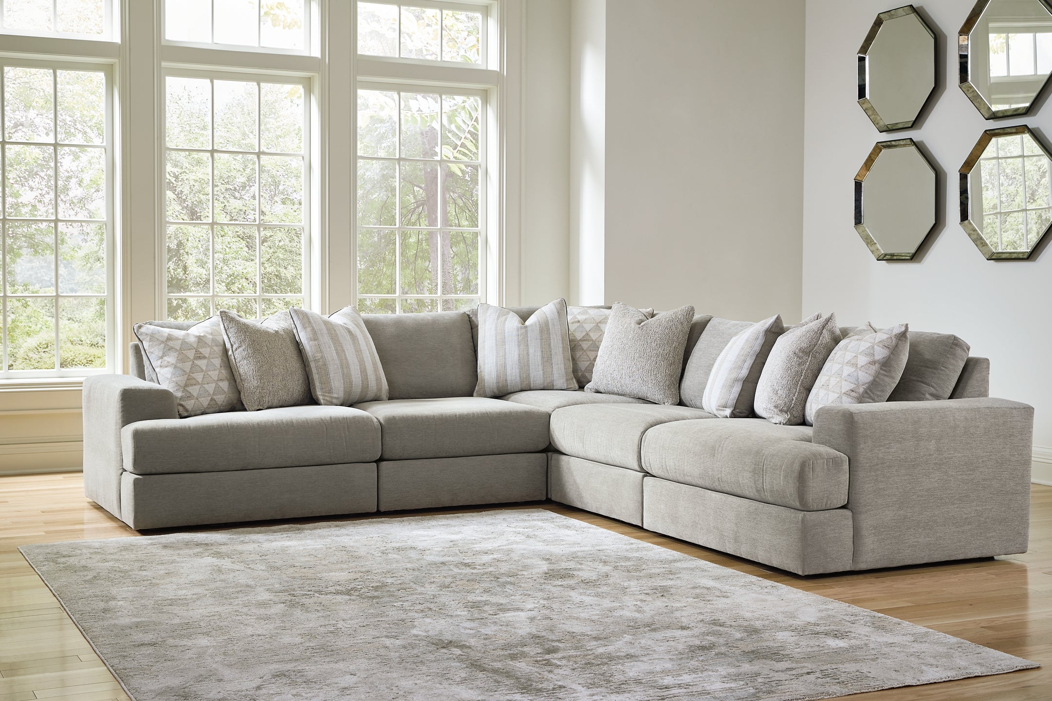Grey Ashley L-shaped sectional sofa in a modern living room setting with plush cushions and fabric upholstery.
