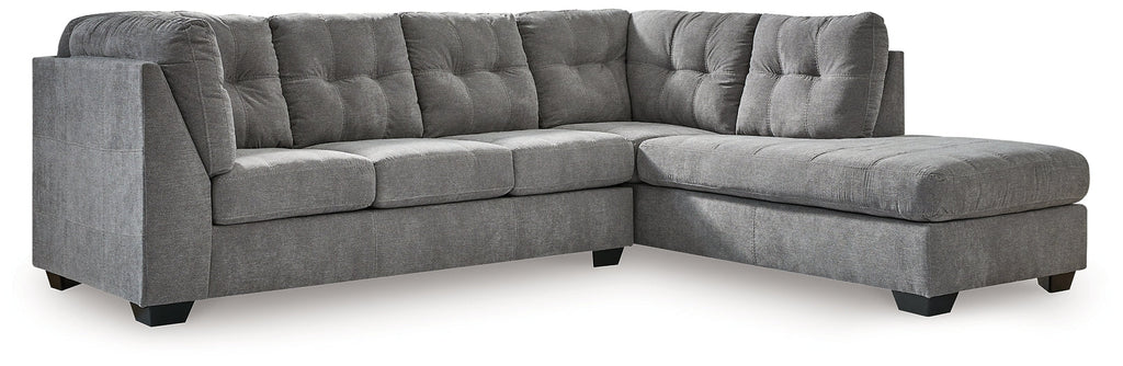Grey L-shaped sectional sofa by Ashley, featuring plush cushions and modern design, shown in a stylish living room setting.