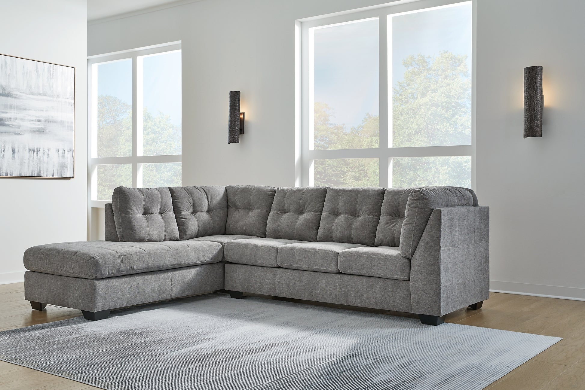 Grey Ashley L-shaped sectional sofa with plush cushions and modern design, shown in a stylish living room setting.