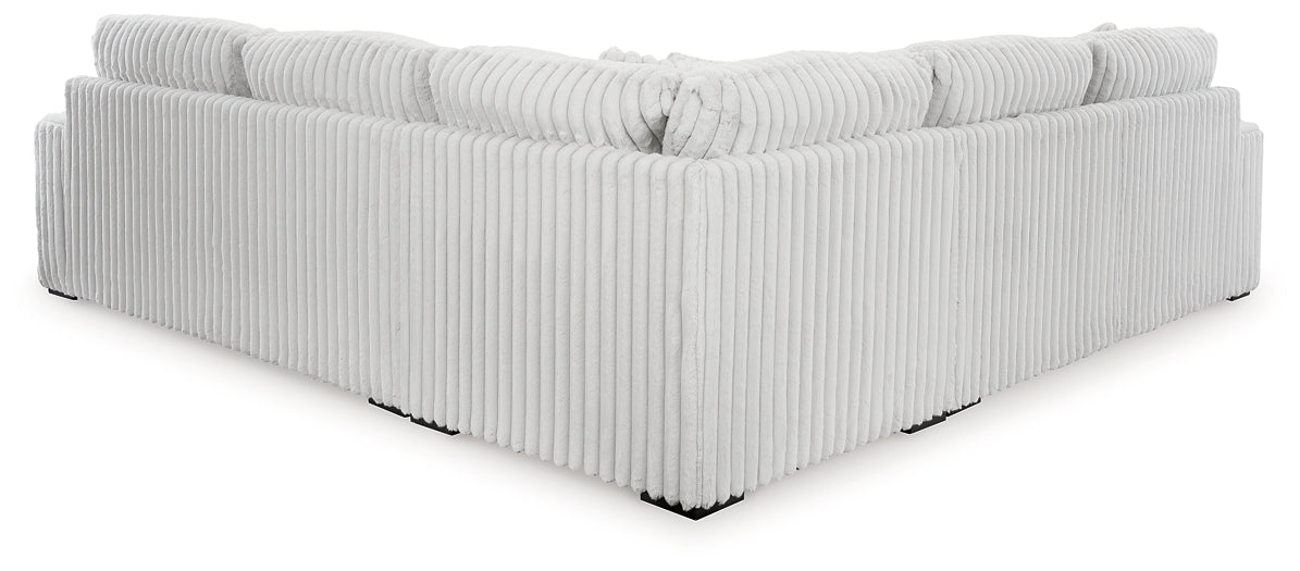 Ashley alloy corduroy L-shaped sectional sofa with plush cushions and modern design, shown in a stylish studio setting.