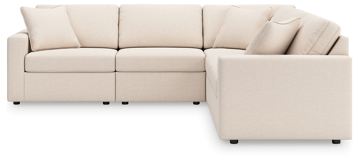 Cream Ashley modular L-shaped sectional sofa in a modern studio setting with plush cushions and clean lines.