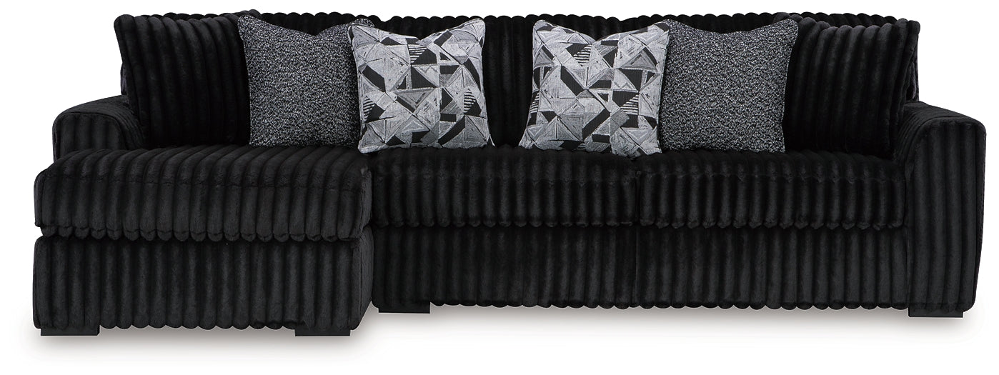 Black corduroy sofa chaise by Signature Design Ashley featuring plush fabric and a modern, comfortable lounge design.