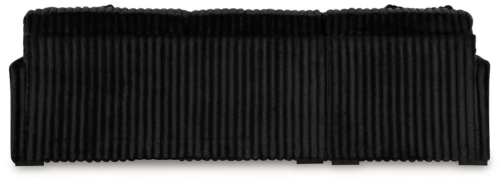 Black corduroy sofa chaise with plush cushions and sleek design from Signature Design by Ashley, shown in a modern studio setting.