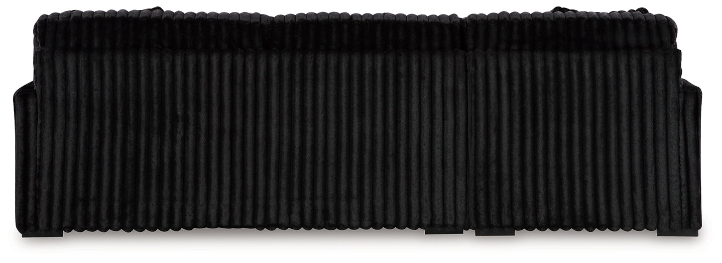 Black corduroy sofa chaise with plush cushions and sleek design from Signature Design by Ashley, shown in a modern studio setting.