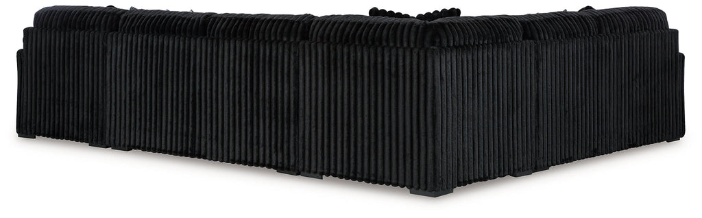 Black corduroy U-shaped sectional sofa by Ashley, featuring plush cushions and modern design in a stylish living room setting.