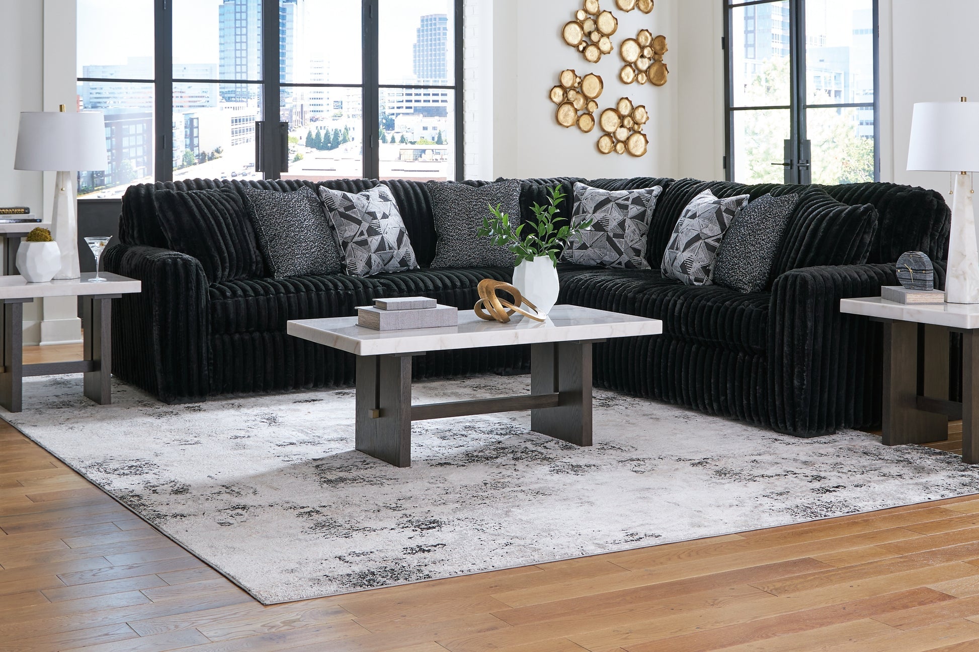Black corduroy L-shaped sectional sofa by Ashley in a modern studio setting, showcasing plush cushions and sleek design.