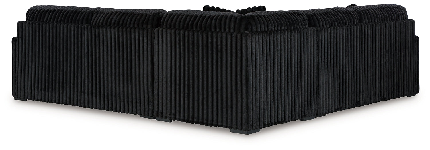 Black corduroy L-shaped sectional sofa by Ashley, showing the plush fabric and modern design in a studio setting.