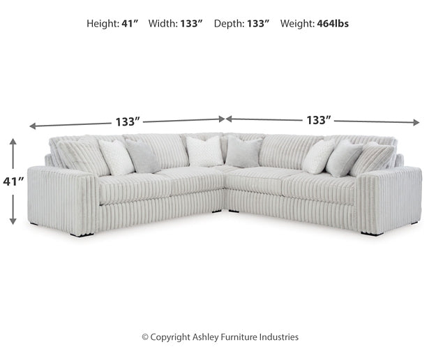 Ashley alloy corduroy L-shaped sectional sofa with plush cushions in a modern studio setting.