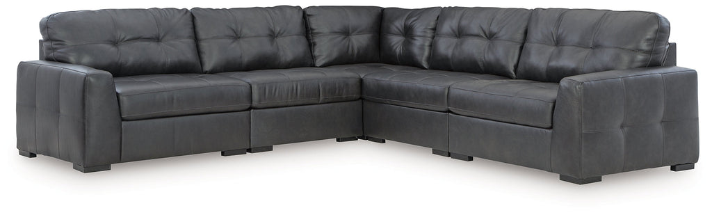 Black genuine leather L-shaped sectional sofa by Ashley, shown in a modern studio setting with plush cushions and sleek design.