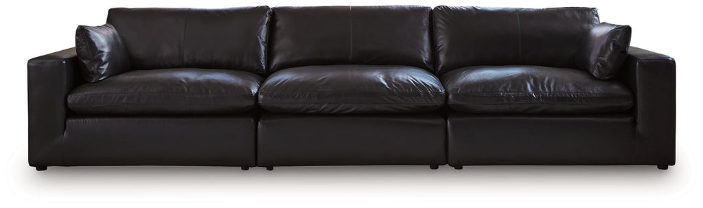 Black genuine leather sectional sofa with three sections, modern design, and plush cushions in a studio setting.