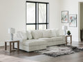 Light grey corduroy sofa chaise by Ashley with plush cushions and modern design, shown in a stylish studio setting.
