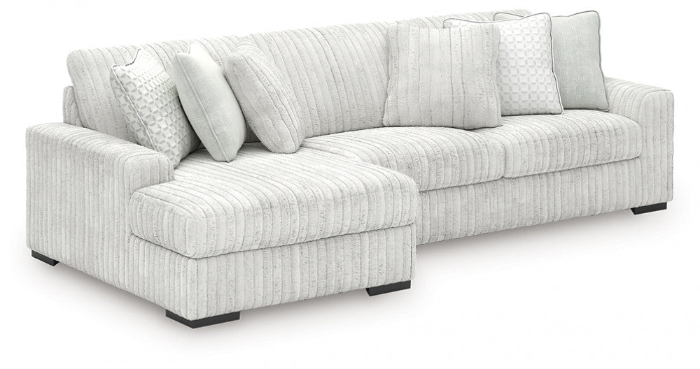 Light grey corduroy sofa chaise from Ashley showing plush fabric and a modern design in a studio setting.