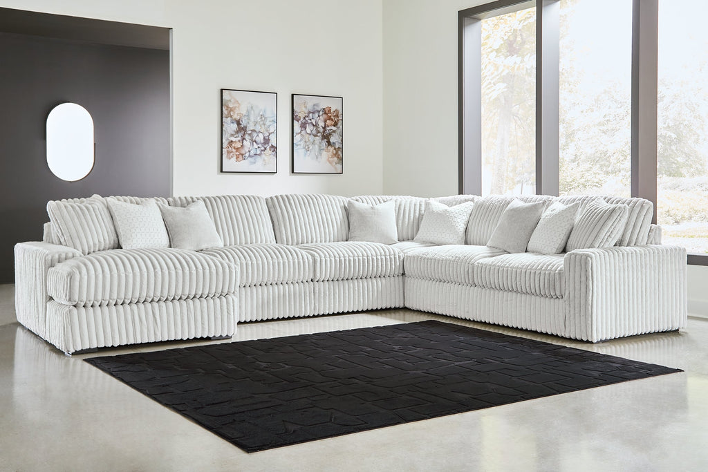 Ivory corduroy U-shaped sectional sofa by Ashley, showcasing plush cushions and modern design in a studio setting.