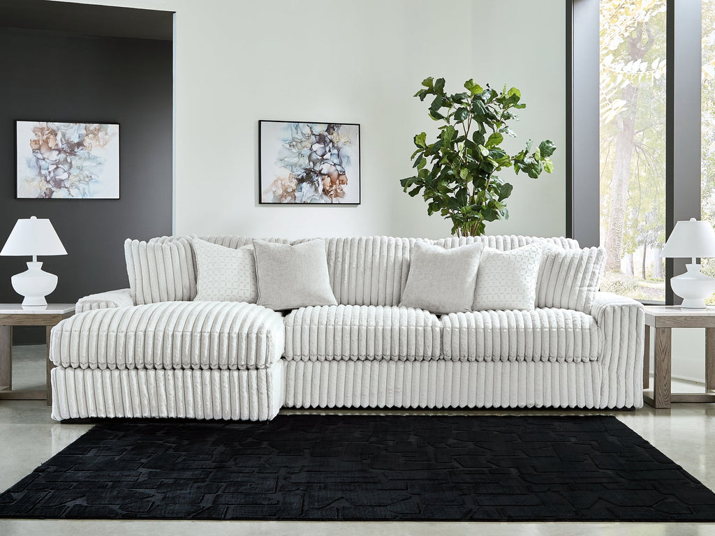 Light grey corduroy sofa chaise by Ashley, showcasing plush fabric and modern design in a studio setting.