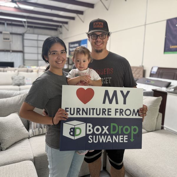 A couple and their baby on a new sectional at BoxDrop Suwanee