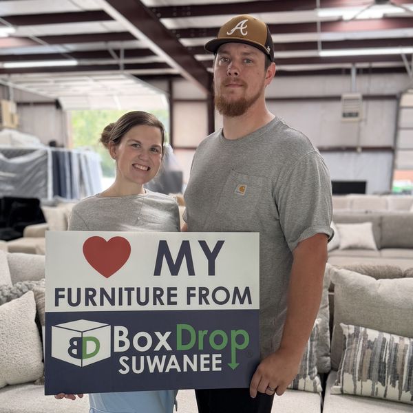 A couple on the BoxDrop Suwanee warehouse floor with their new sofa