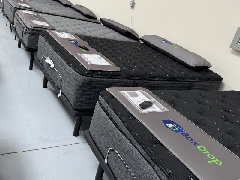 Name-brand mattresses lined up on the BoxDrop Suwanee floor